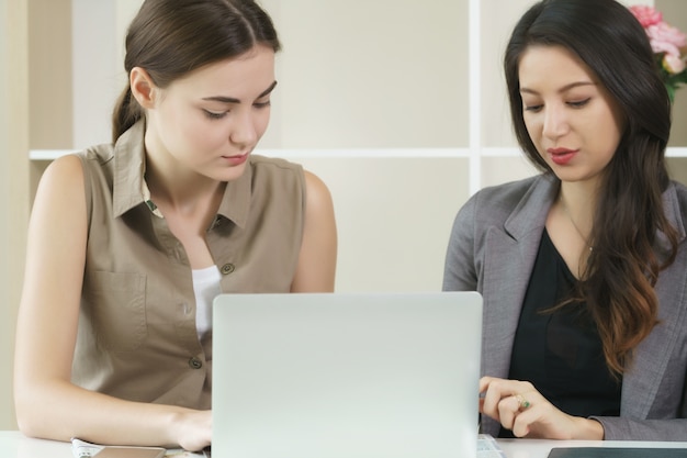 Une femme d&#39;affaires travaille dans le bureau tout en ayant une conversation d&#39;affaires avec une autre femme.