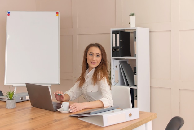 Femme d'affaires travaille dans un ordinateur portable. portrait d'une femme au bureau.