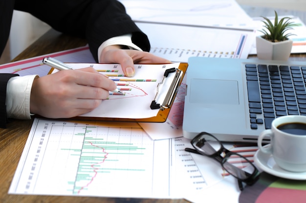 Femme d'affaires travaille avec des éléments pour faire des affaires au bureau.