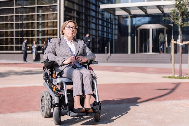 Femme d'affaires utilisant un fauteuil roulant dans la rue