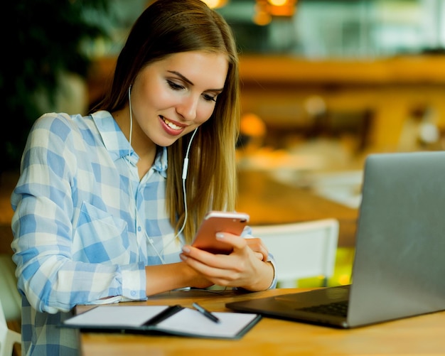 Femme d'affaires utilisant un ordinateur portable au café fille assise dans un café et travaillant sur ordinateur