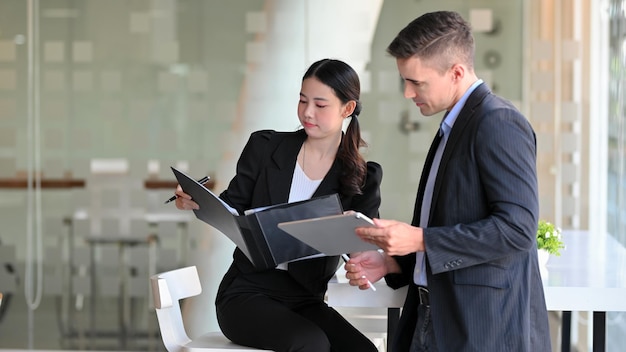 Femme d'affaires utilisant un ordinateur portable debout au bureau