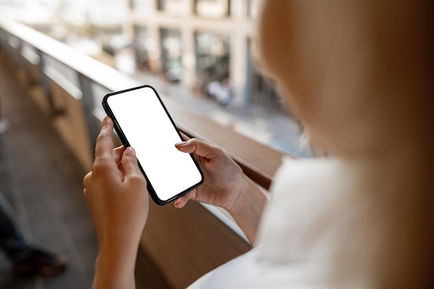 Femme d'affaires utilisant son téléphone portable sur le balcon