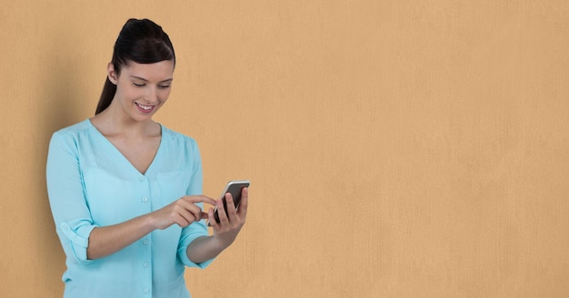 Femme d'affaires utilisant un téléphone portable sur fond beige