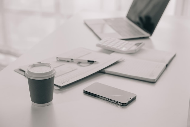 Photo femme d'affaires utilisant un téléphone portable pendant le travail sur un ordinateur portable surfant sur internet recherchant des données commerciales dans un bureau moderne femme d'affaires asiatique en ligne travaillant sur ordinateur sur le lieu de travail