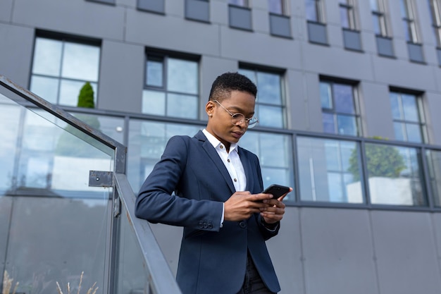 Femme d'affaires utilisant un téléphone portable, travailleur afro-américain sérieux à l'extérieur du bureau