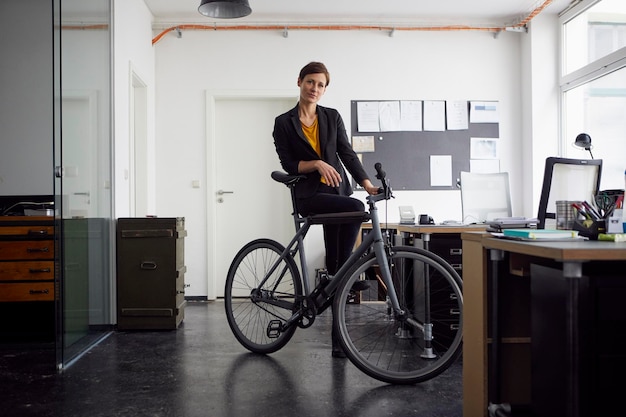 Photo femme d'affaires avec vélo dans sa start-up