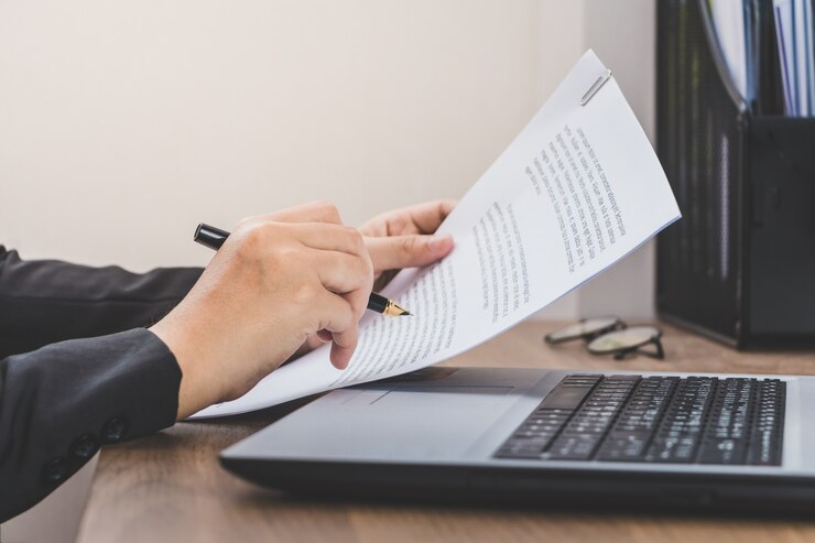 Photo femme d&#39;affaires vérifiant le papier, travaillant avec ordinateur portable et des documents sur son bureau