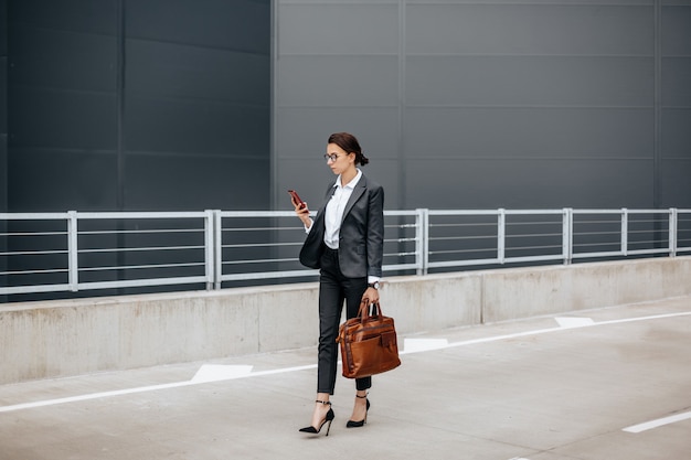 Une femme d'affaires vérifie l'heure dans la ville au cours d'une journée de travail en attente d'une réunion