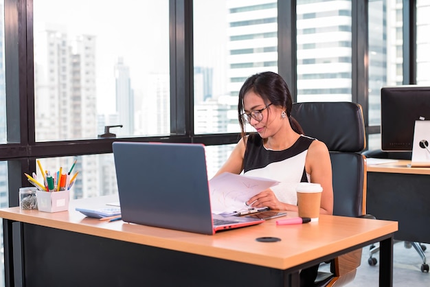 Femme d'affaires vérifier le document dans un bureau moderne