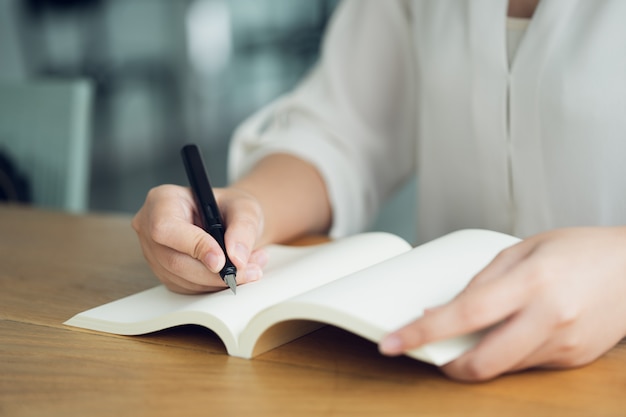 Femme d&#39;affaires, voyageur, auteur d&#39;article Tenez le stylo pour écrire le texte