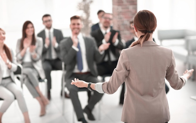 Une femme d'affaires de vue arrière fait un rapport pour les employés