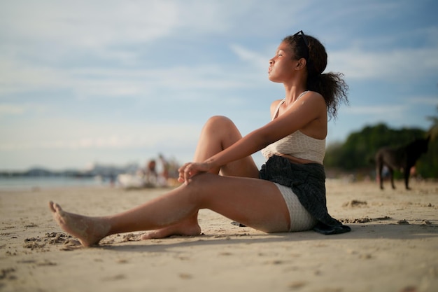 Femme africaine assise sur la plage Portrait sexy femme africaine voyage ping et se détendre en été avec la nature tropicale