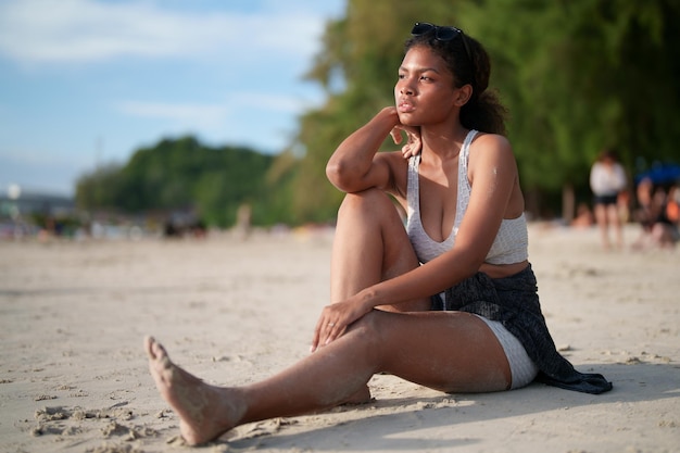 Femme africaine assise sur la plage Portrait sexy femme africaine voyage ping et se détendre en été avec la nature tropicale