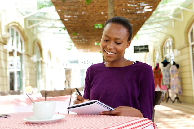 Femme africaine écrivant dans un café