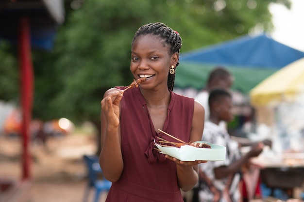 Femme africaine mangeant de la nourriture de rue