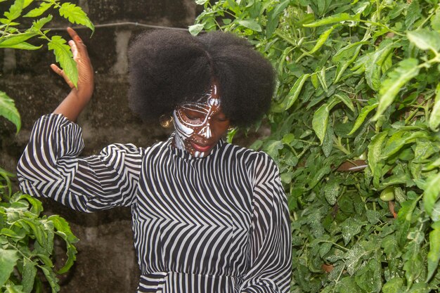 Photo une femme africaine avec un masque sur un champ naturel