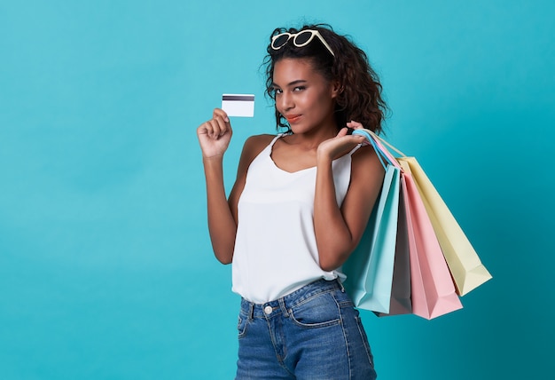 Femme africaine montrant une carte de crédit et des sacs