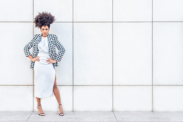 Une femme africaine s'habille dans des vêtements formels de modélisation en regardant la caméra, vue en gros plan