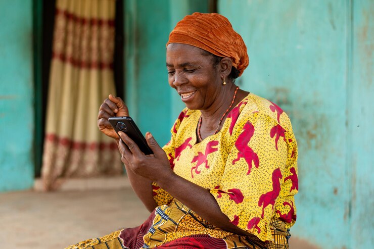 Une femme africaine se réjouit avec son smartphone.