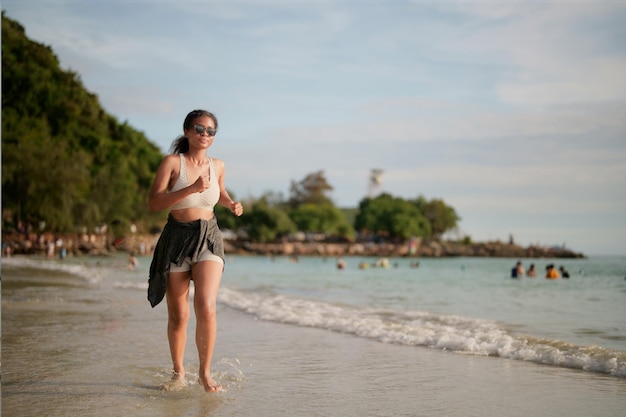 Femme africaine en soutien-gorge de sport court sur la plage pour une séance d'entraînement en plein air
