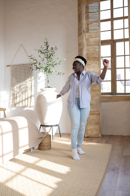 Photo femme africaine en vêtements légers passant du temps à la maison