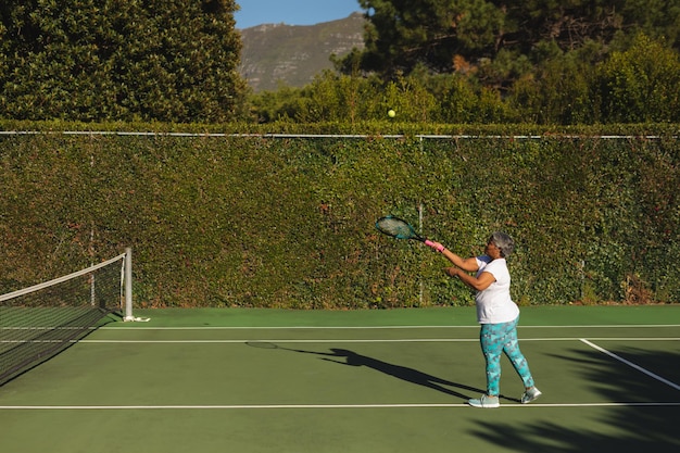 Photo une femme afro-américaine âgée joue au tennis sur un court de tennis.