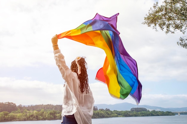 Femme afro-américaine agitant le drapeau arc-en-ciel lgtb