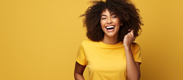 Photo une femme afro-américaine aux cheveux bouclés rit des points à côté avec du papier déchiré portant une chemise noire isolée sur fond jaune