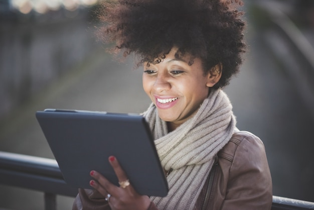 Photo femme afro-américaine de beaux cheveux bouclés avec tablette