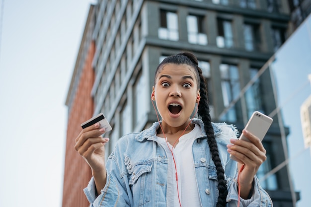 Femme Afro-américaine Avec Carte De Crédit, à L'aide De Smartphone, Achats En Ligne