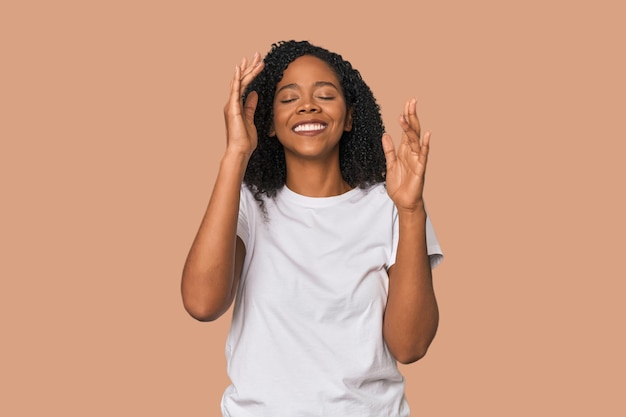 Une femme afro-américaine dans un studio, joyeuse, riant beaucoup, concept de bonheur.