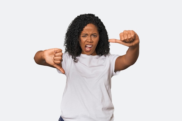 Une femme afro-américaine dans un studio montrant le pouce vers le bas et exprimant son aversion