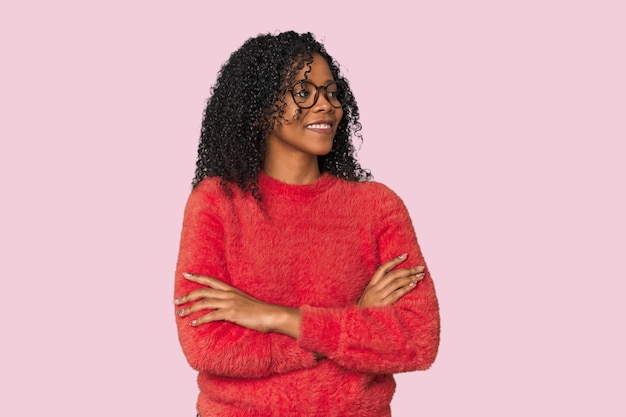 Une femme afro-américaine dans un studio souriante confiante avec les bras croisés