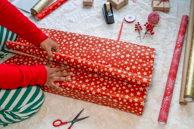 Femme afro-américaine emballant des cadeaux de Noël