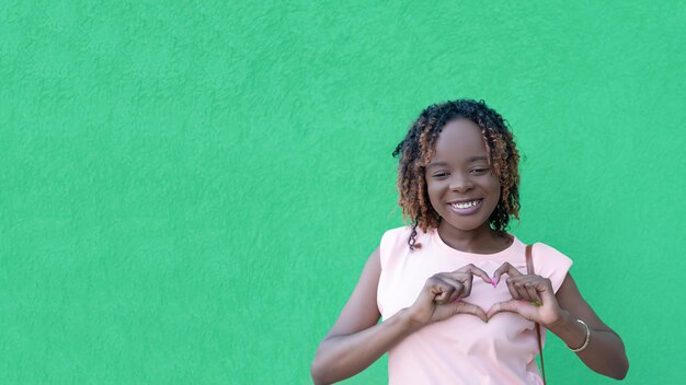 Une femme afro-américaine heureuse sur fond vert Love Gestures Copy space