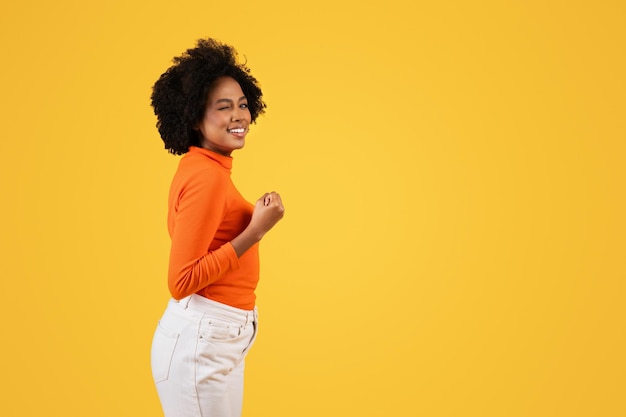 Photo une femme afro-américaine heureuse avec un sourire subtil regardant par-dessus son épaule