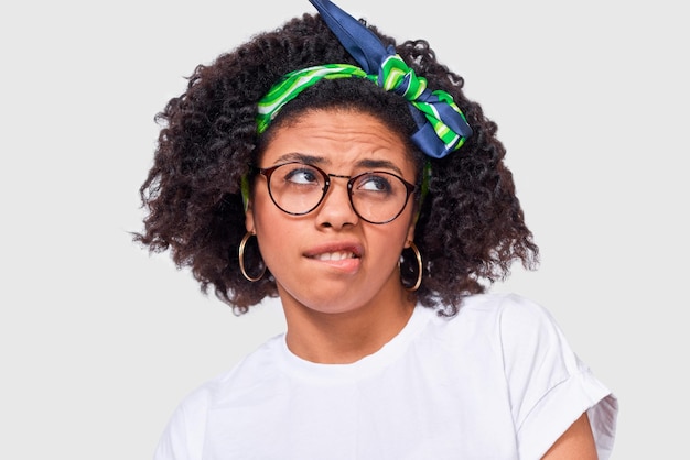 Une femme afro-américaine incertaine a une expression perplexe fronce les sourcils et lève les yeux