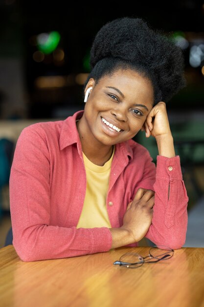 Femme afro-américaine millénaire regardant dans la caméra et souriant