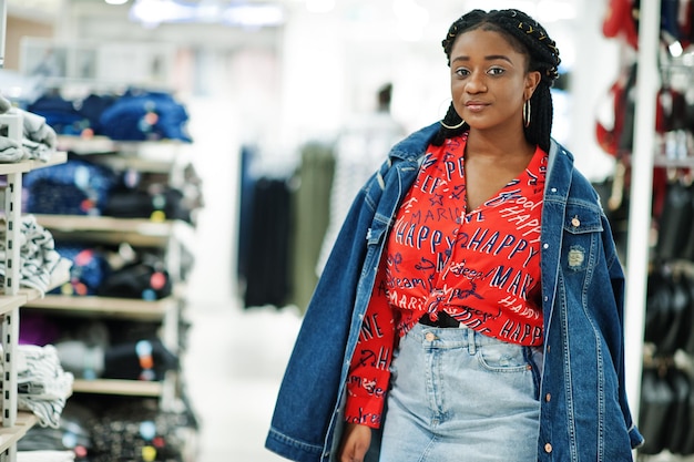 Femme Afro-américaine à La Mode En Chemise Rouge Et Jupe En Jean Avec Veste Posée Au Magasin De Vêtements Il Est Temps De Faire Du Shopping