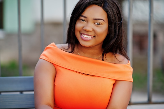 Femme afro-américaine modèle XXL en robe orange.