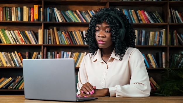 Une femme afro-américaine participe à une conférence en ligne