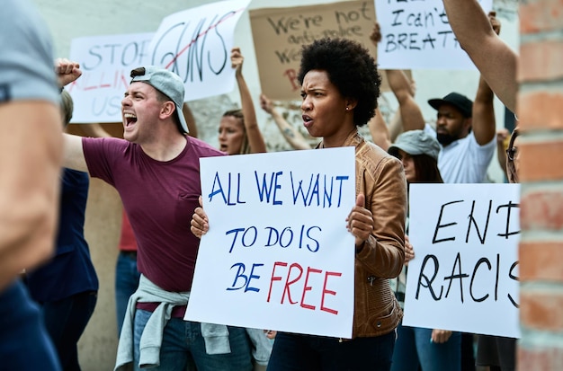 Femme afro-américaine portant une bannière tout en participant à des manifestations contre le racisme dans les rues de la ville