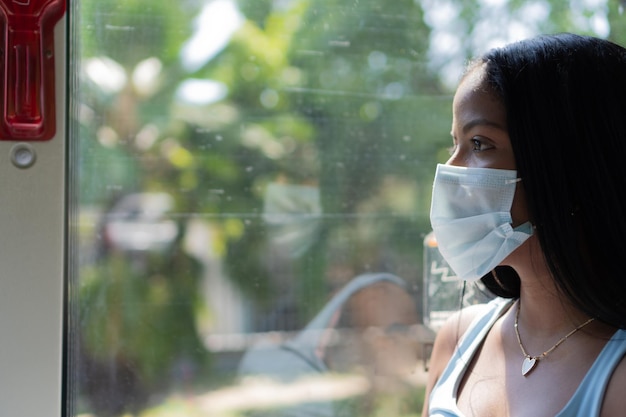 Femme afro-américaine portant un masque de protection à bord d'un bus pendant une pandémie