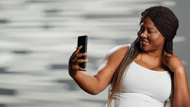 Une femme afro-américaine posant sur une caméra de smartphone
