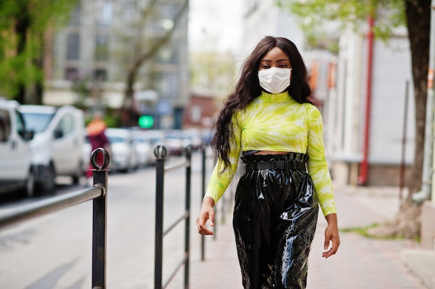 Femme afro-américaine posant avec un masque facial pour se protéger des infections contre les bactéries, les virus et les épidémies.