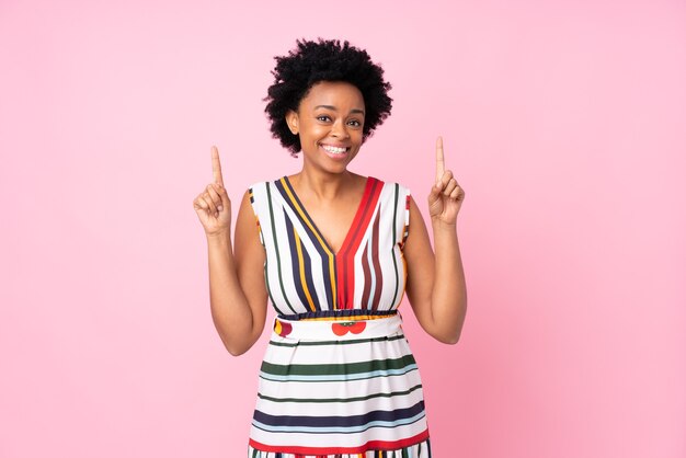 Femme afro-américaine sur rose isolé pointant vers le haut une excellente idée