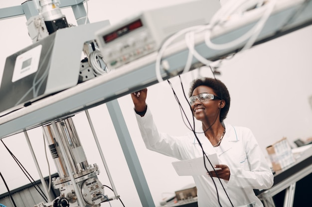 Femme afro-américaine scientifique travaillant en laboratoire avec un détecteur de photon unique de technologie électronique r ...