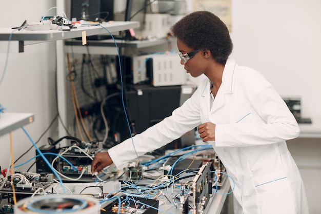 Femme afro-américaine scientifique travaillant en laboratoire avec la recherche et le développement de technologies électroniques d'appareils électroniques par couleur femme noire