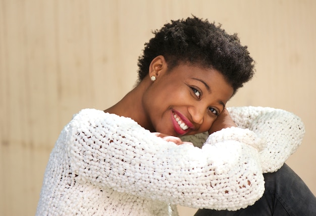 Femme afro-américaine souriante, assis à l&#39;extérieur